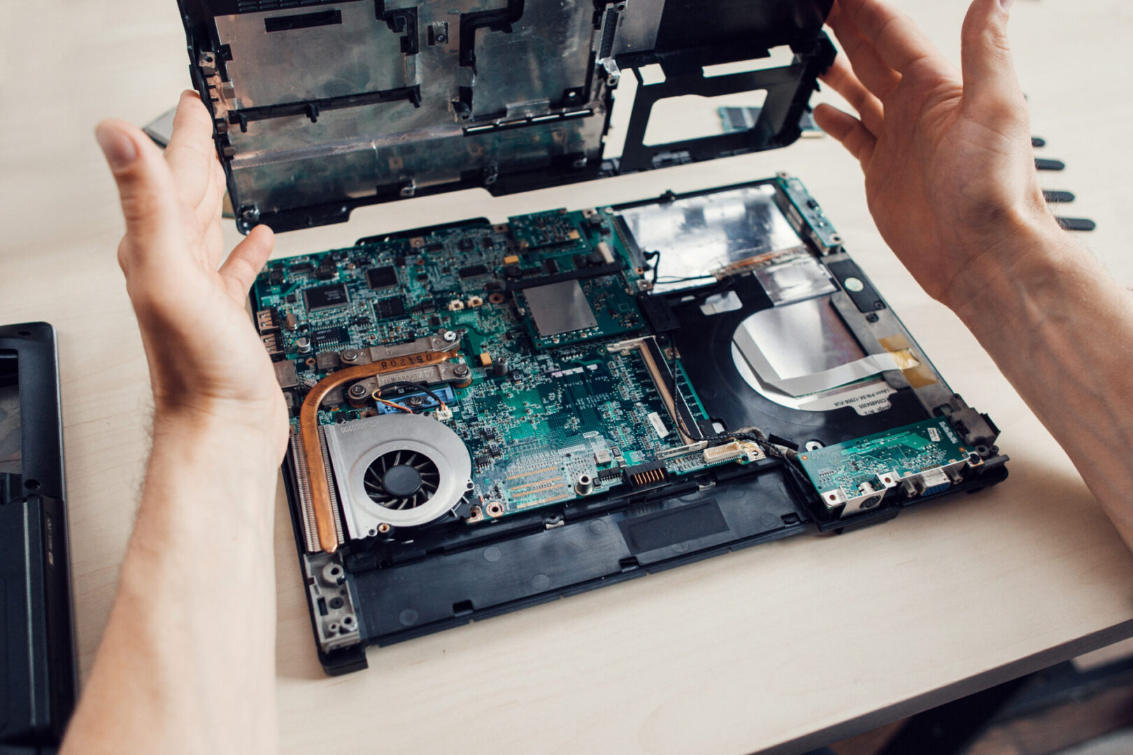 Laptop repair with open internal components shown.