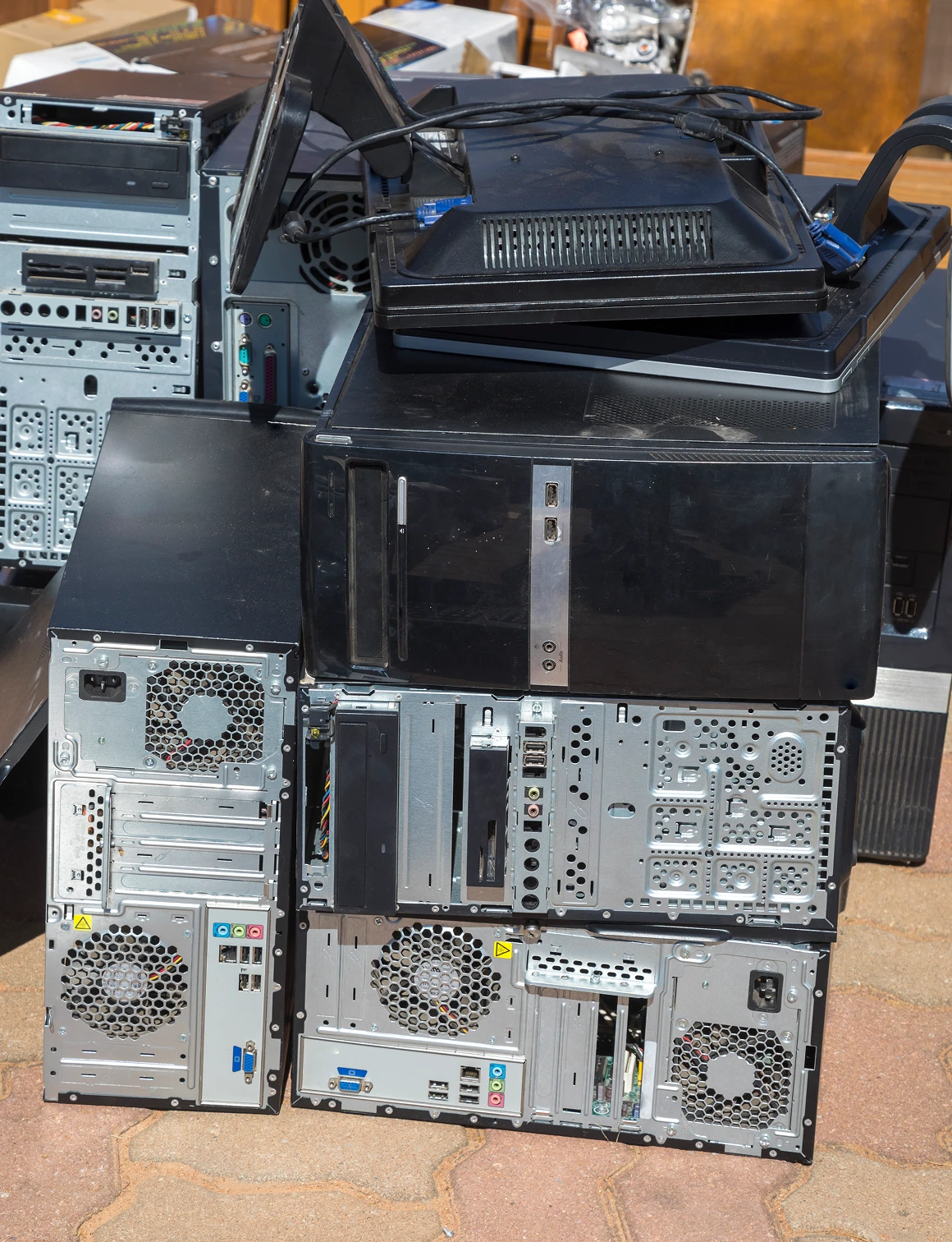 Stacked old computer towers and monitors.