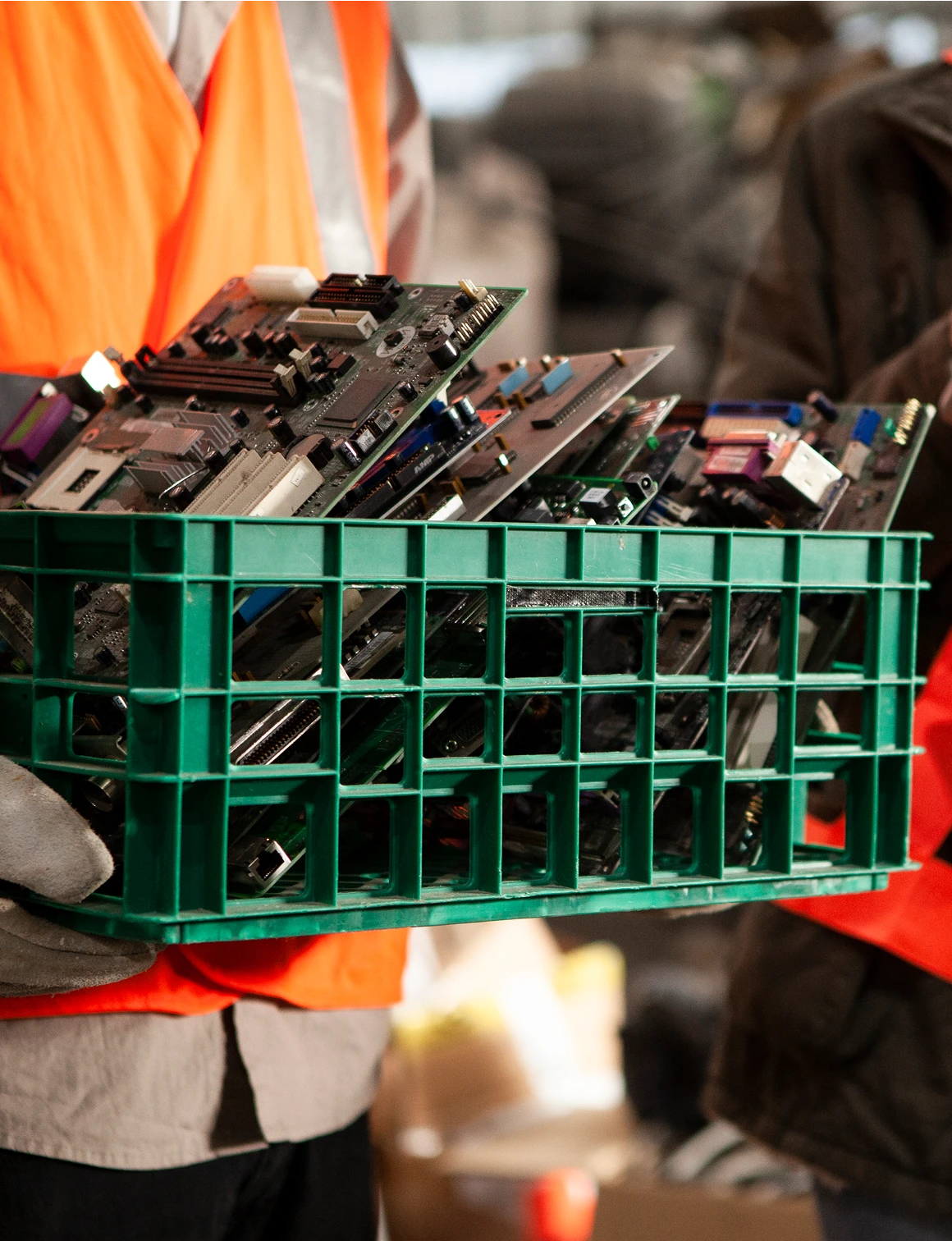 Person holding crate of electronic circuit boards.