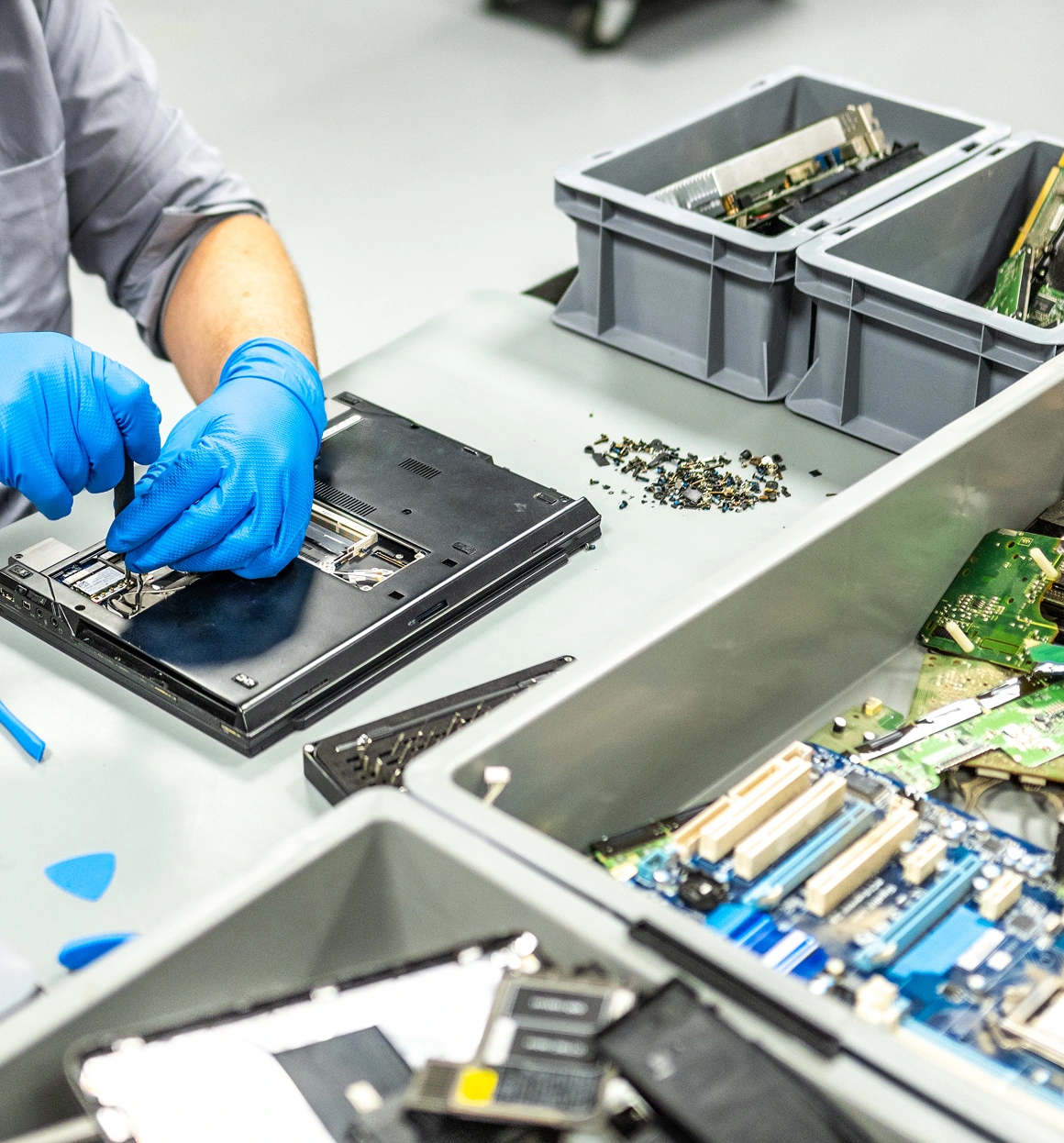Technician repairing electronic device with gloves.