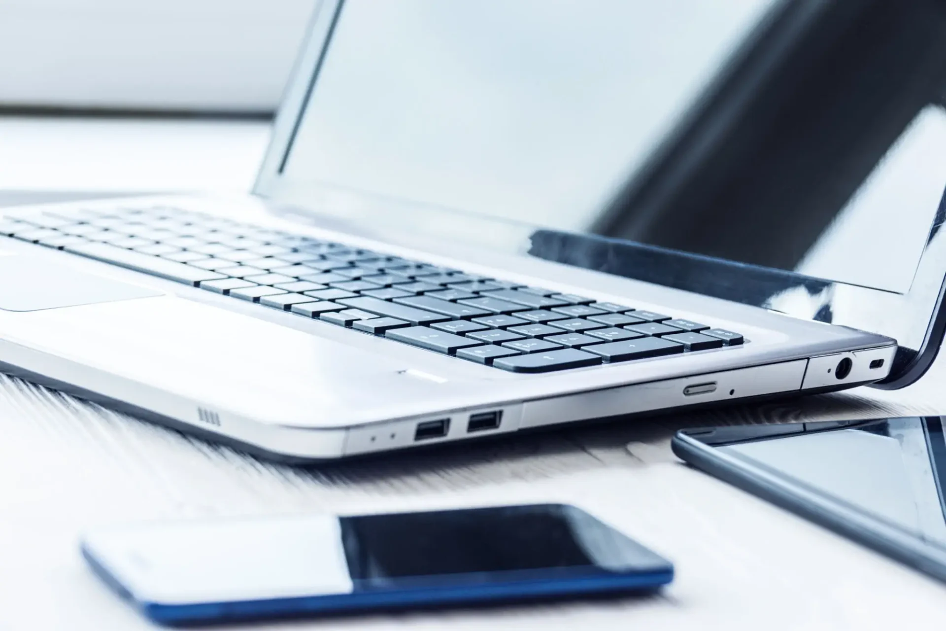 Open laptop with smartphone and tablet nearby
