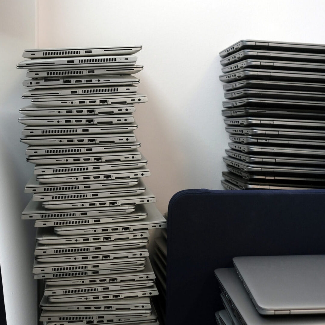 Stacks of closed laptops on shelves.